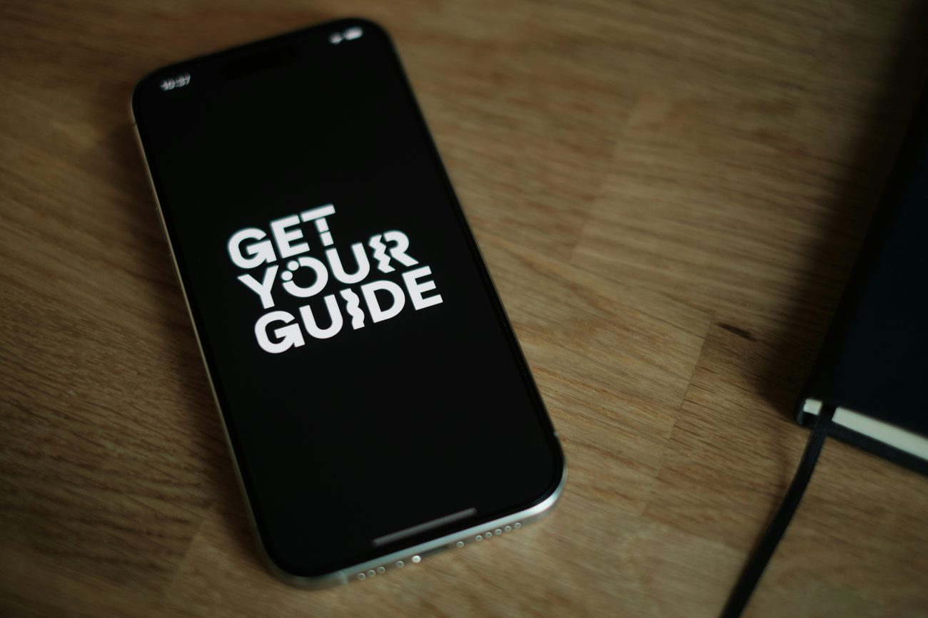 Un téléphone posé sur un bureau affiche le livret digital d'une location