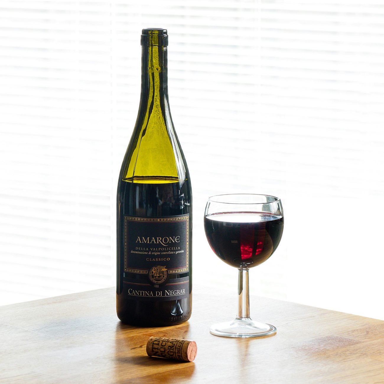 Une bouteille de vin et un verre servi, en guise de bienvenue pour le client
